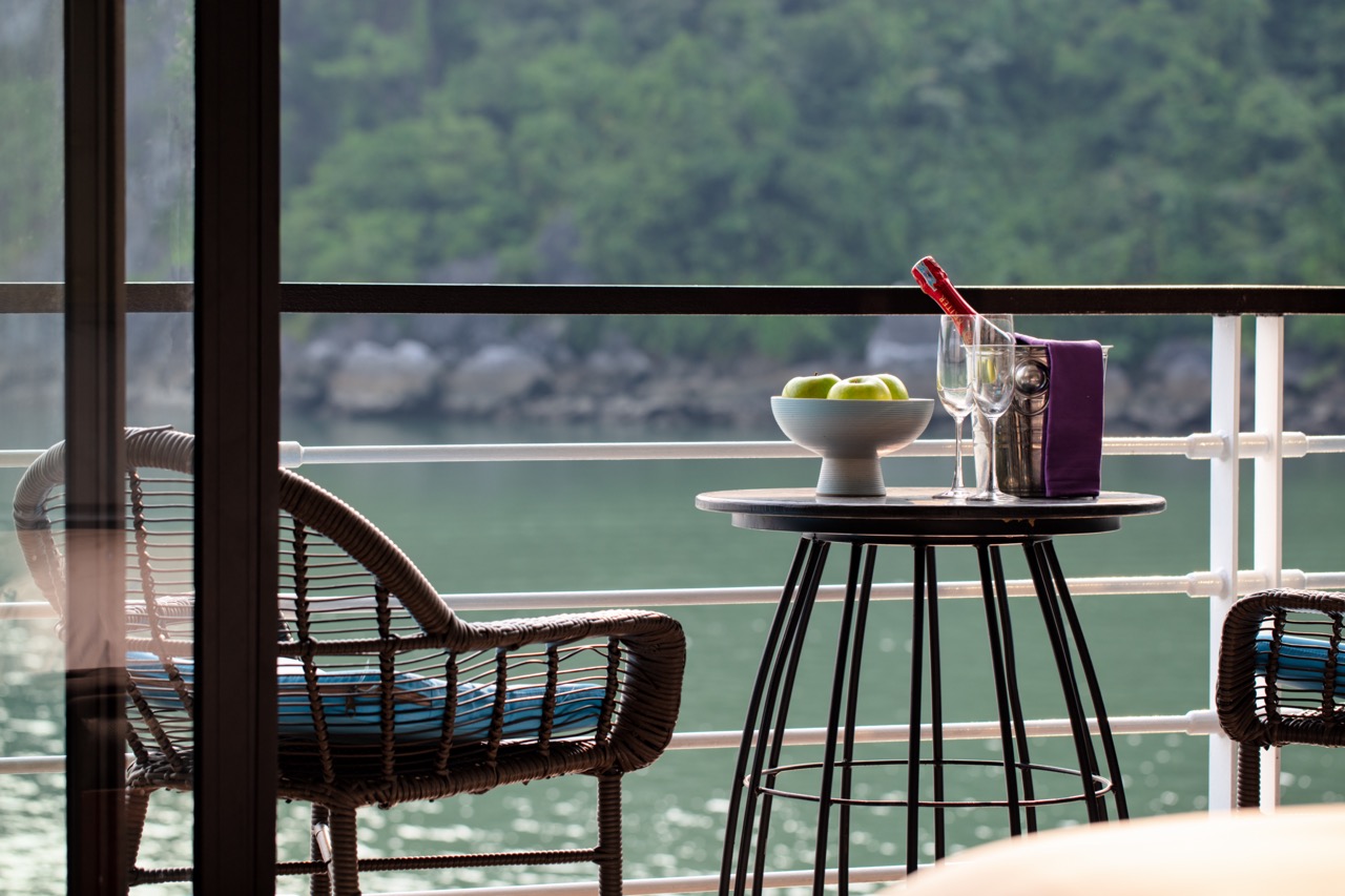 Relaxing view of Halong Bay from cruise balcony with scenic water and lush green islands.