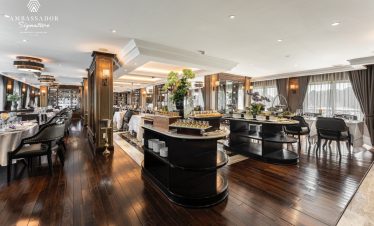 Elegant cruise dining area with sophisticated decor and panoramic windows, perfect for a relaxing Ha.