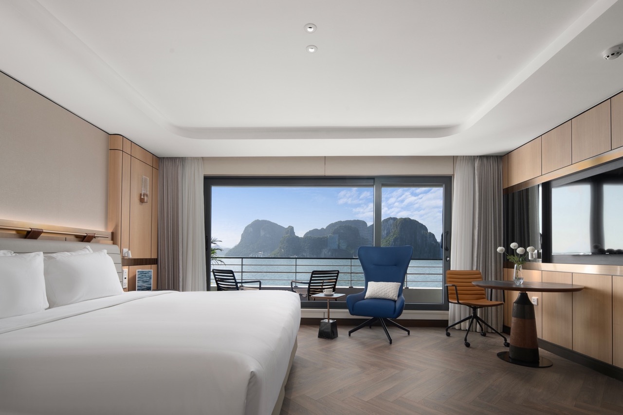 Elegant hotel room with ocean view, modern furnishings, and balcony in Vietnam.