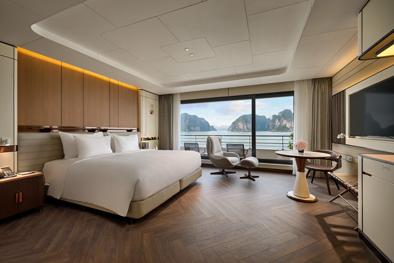Luxury hotel room with ocean view in Vietnam, featuring modern design and balcony overlooking limestone islands.