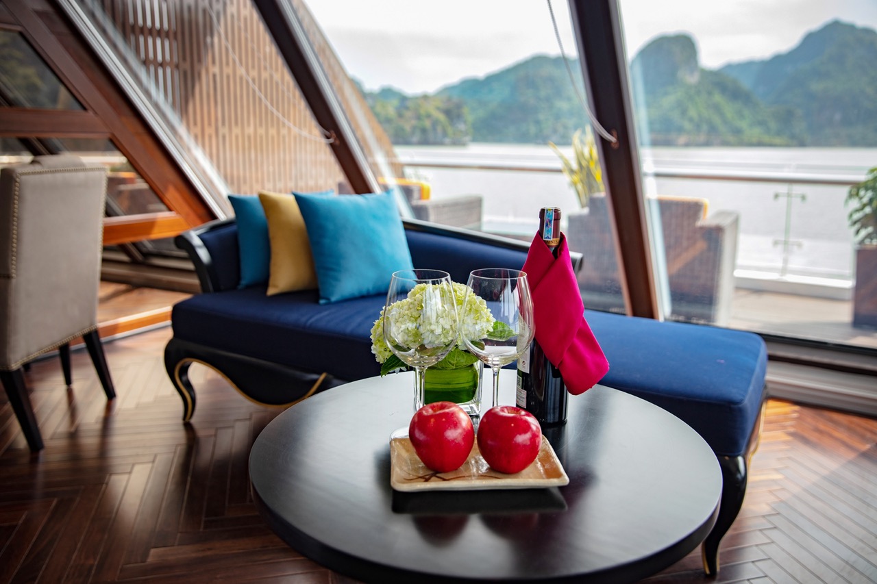 Luxurious cruise ship interior with scenic mountain view, elegant decor, and wine setup for travelers.