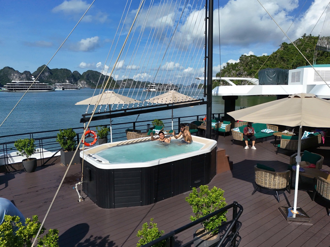 Hot tub with guests enjoying the view on Lan Ha Bay cruise, surrounded by scenic limestone islands a.