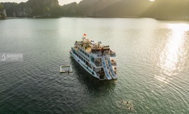 Scenic cruise boat on Lan Ha Bay with stunning limestone karsts at sunset, perfect for relaxing trav.