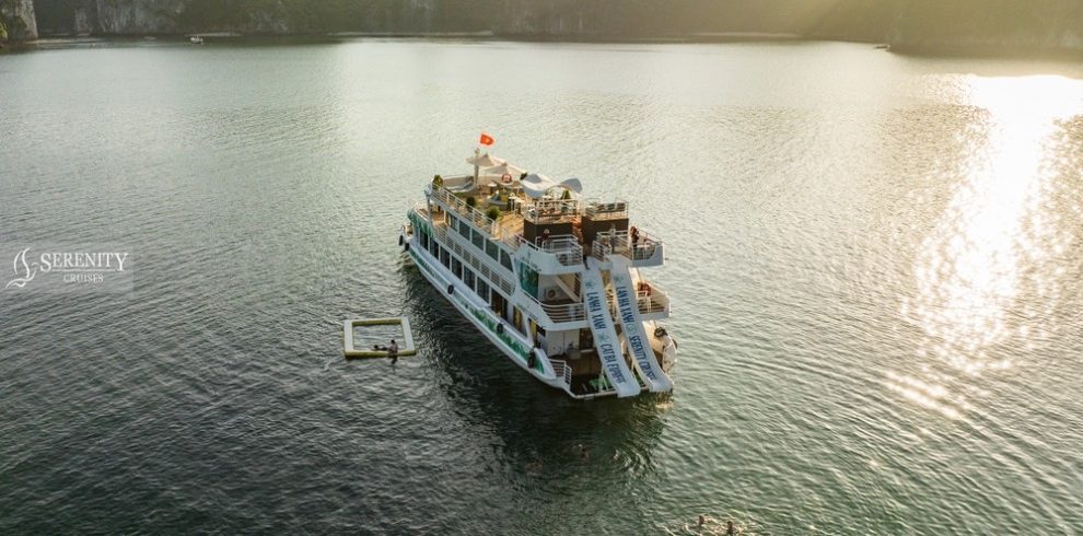 Scenic cruise boat on Lan Ha Bay with stunning limestone karsts at sunset, perfect for relaxing trav.