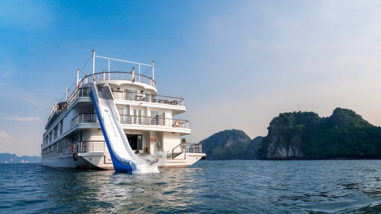 A cruise ship sailing on Halong Bay with scenic limestone islands in the background, perfect for a r.