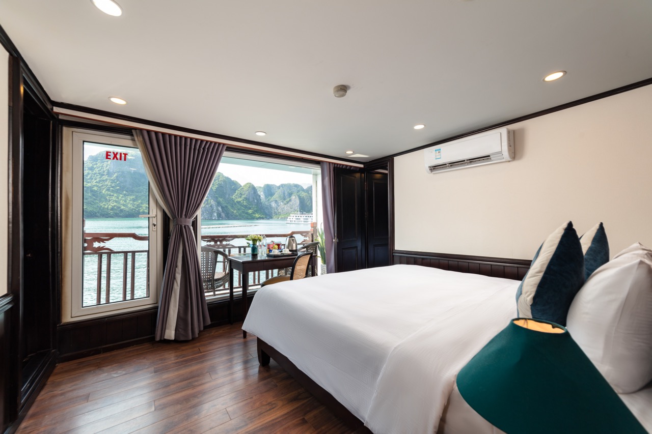 Lake view hotel room with balcony, modern decor, and scenic landscape in Vietnam.