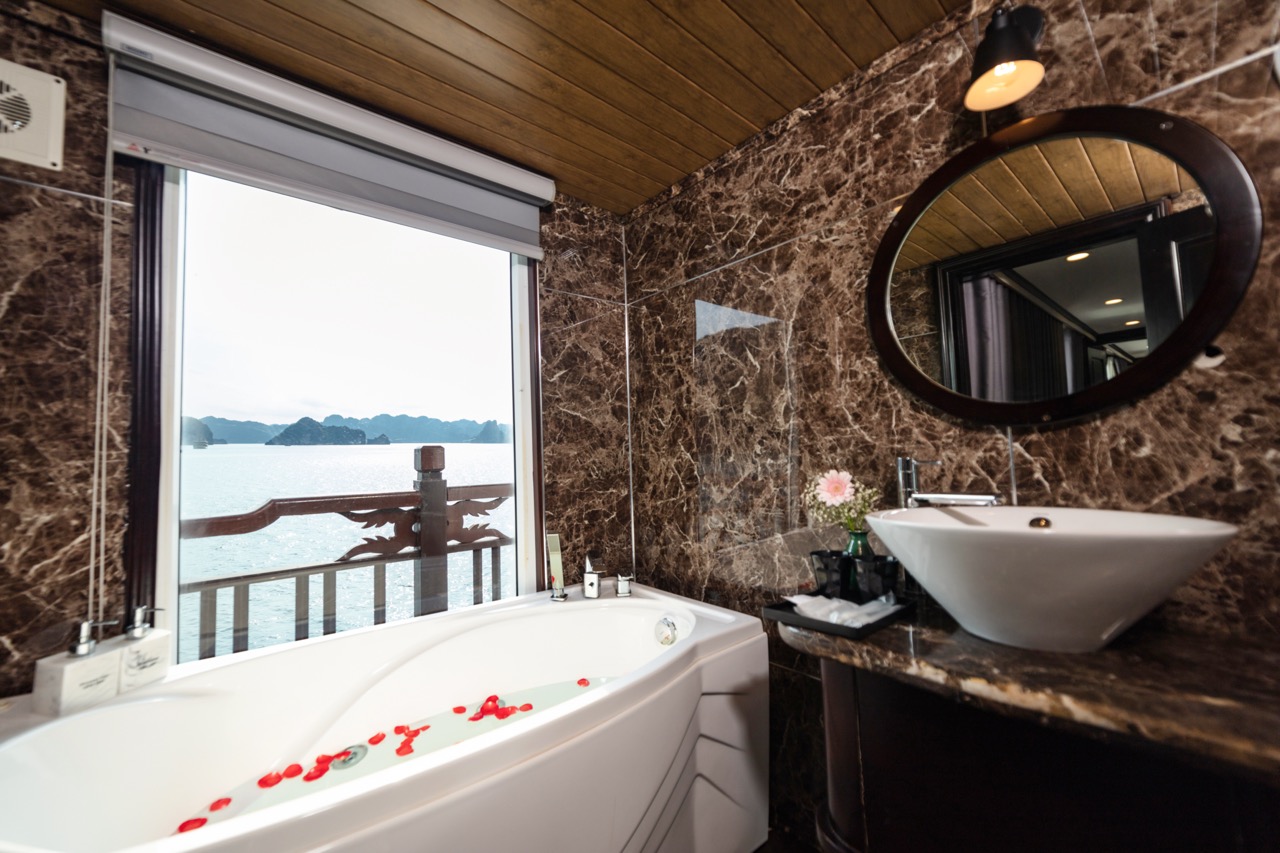 Luxurious bathroom with bathtub overlooking scenic sea view and island landscape.