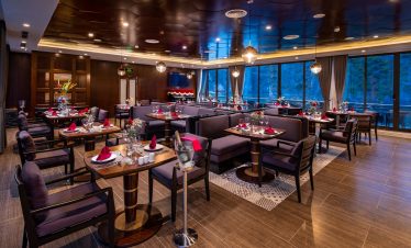 Luxurious restaurant interior with elegant table settings and modern decor.
