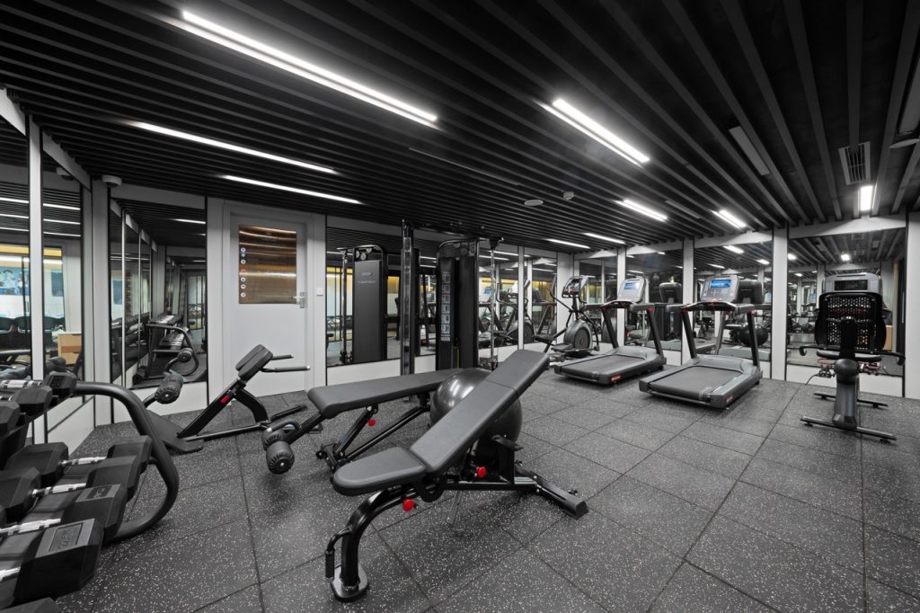 Modern gym with cardio and strength equipment in a sleek, well-lit fitness center.