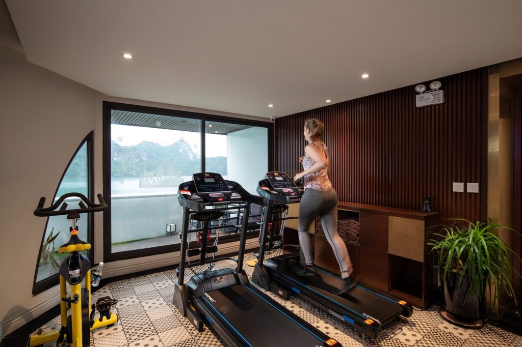- Modern indoor gym with treadmill and exercise bike overlooking scenic mountain view.