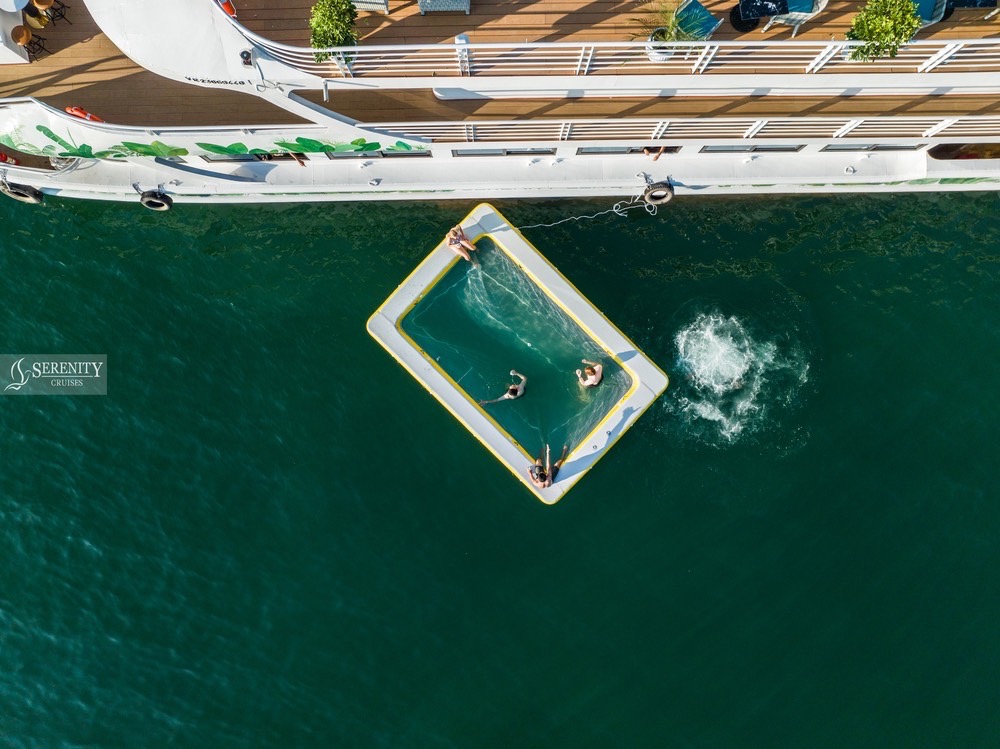 Aerial view of a luxury cruise balcony with a swimming pool in Halong Bay, showcasing serene waters.