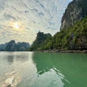 Tranquil river surrounded by lush green limestone mountains in Vietnam.