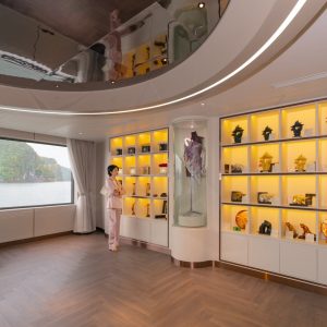 Elegant interior of a tour agency with display shelves showcasing souvenirs and scenic lake view through large windows.