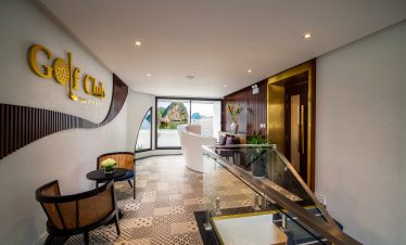 Luxury golf club lounge with ocean views and elegant decor, perfect for relaxation and socializing.