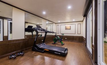 Indoor gym with treadmill and exercise bike for guests on Mon Cheri Cruise Halong Bay 1 night.