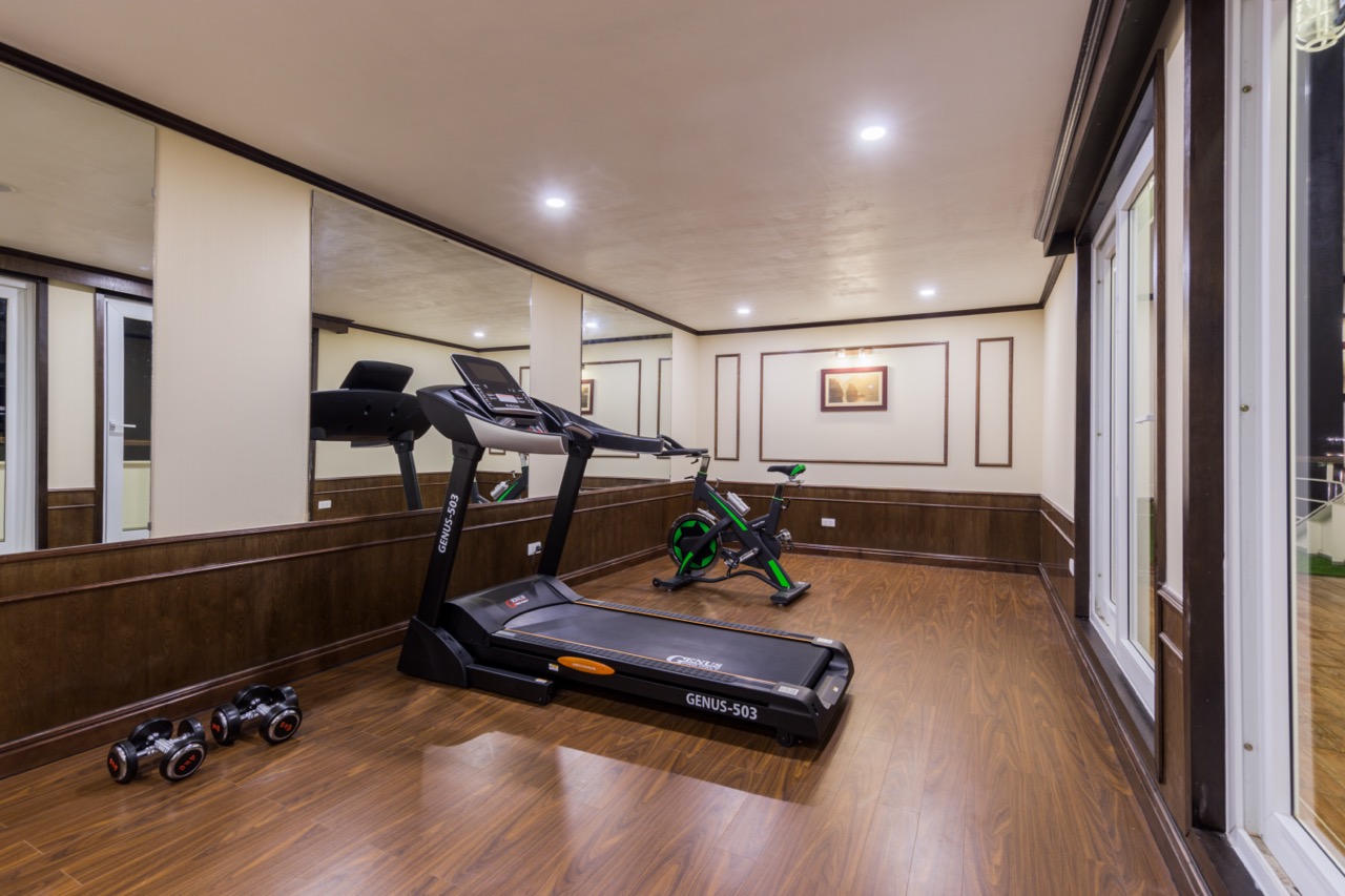 Indoor gym with treadmill and exercise bike for guests on Mon Cheri Cruise Halong Bay 1 night.