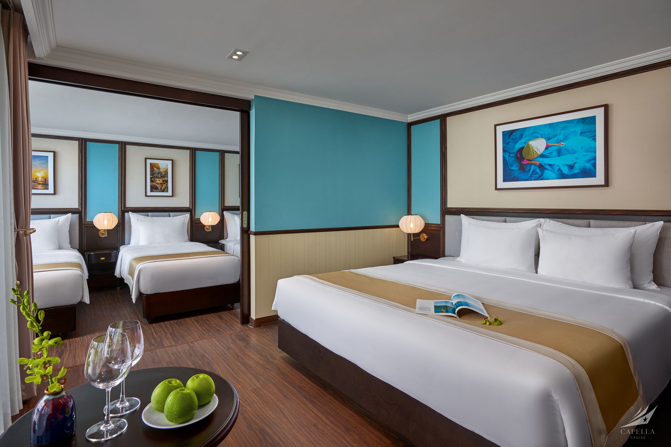 Comfortable modern hotel room with twin beds, stylish decor, and vibrant artwork in Vietnam.