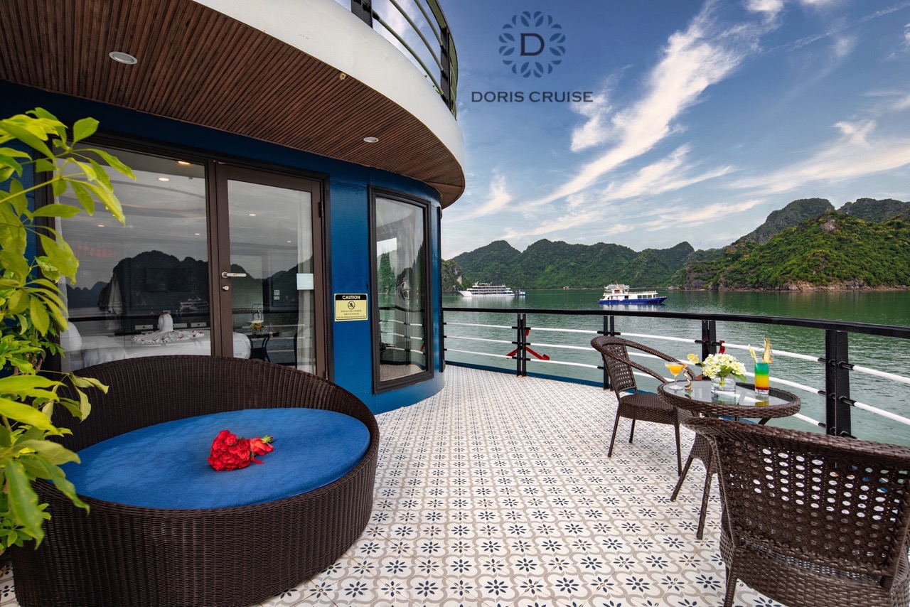 Scenic Halong Bay view from cruise balcony with relaxing seating and lush green islands in the backg.
