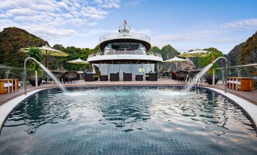Luxurious yacht with swimming pool and scenic mountain views in Halong Bay, Vietnam.