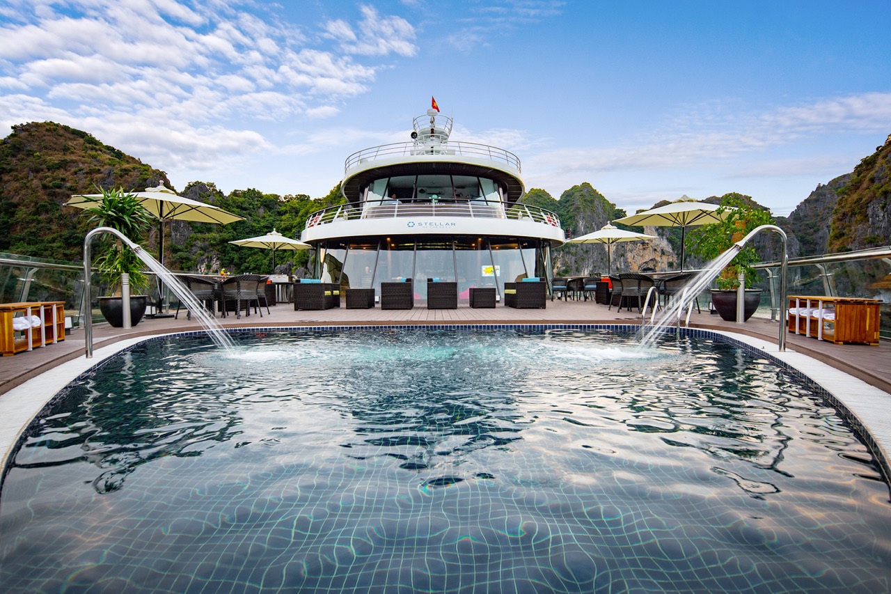 Luxurious yacht with swimming pool and scenic mountain views in Halong Bay, Vietnam.