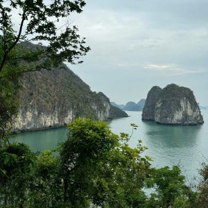 Limestone karsts and emerald waters of Ha Long Bay, Vietnam, surrounded by lush greenery.