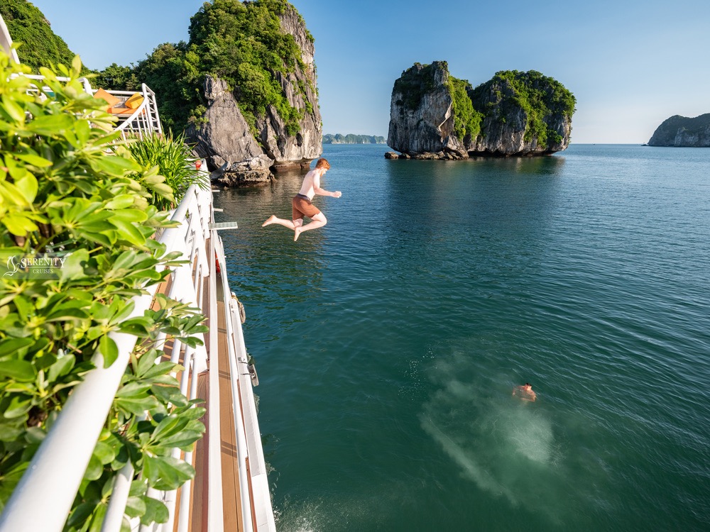 Jumping into the clear waters of Lan Ha Bay from Serenity Cruise, Vietnam, with stunning limestone k.