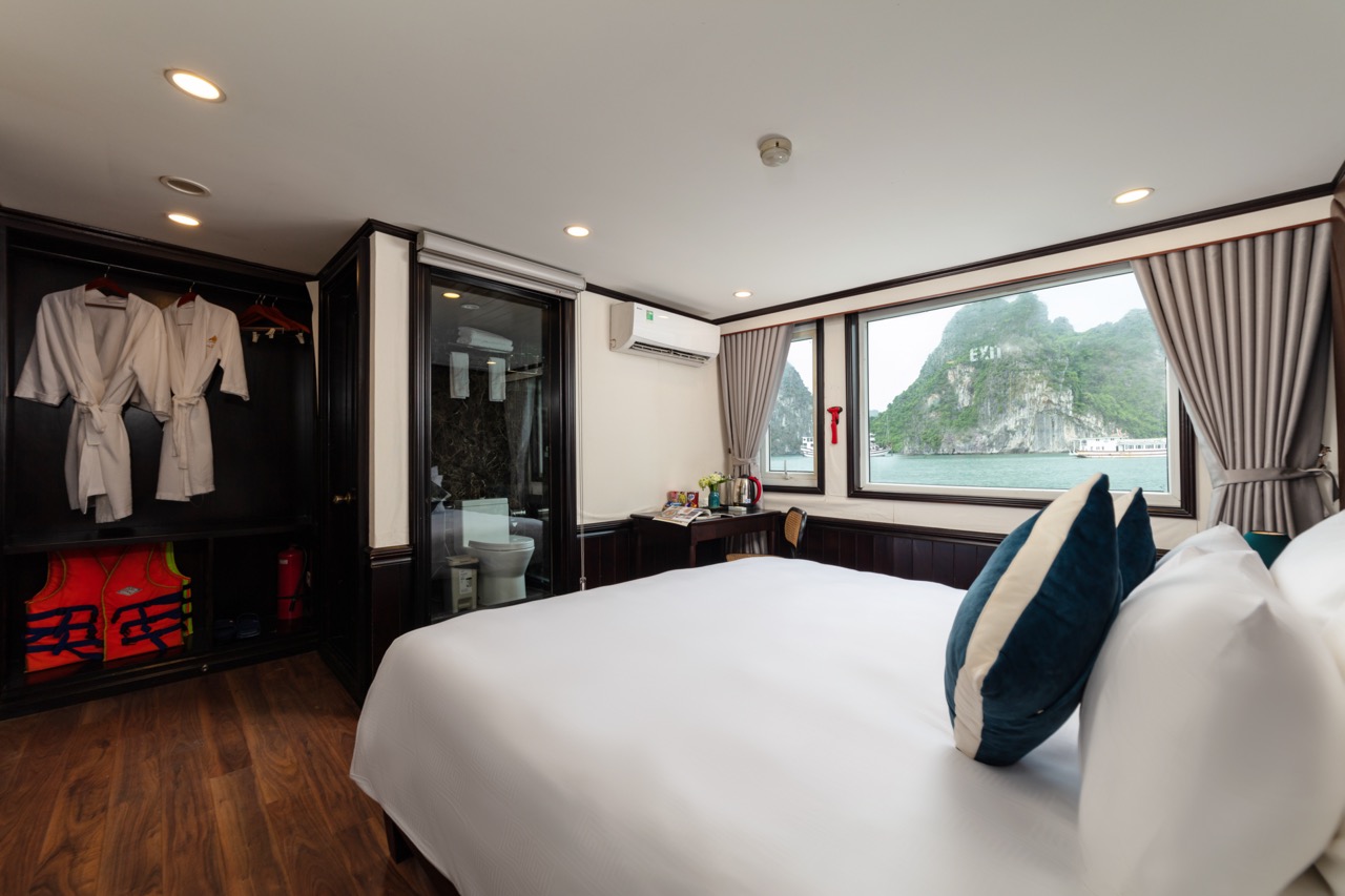 Cozy hotel room with waterfront view in Ha Long Bay, modern amenities, and comfortable bedding.