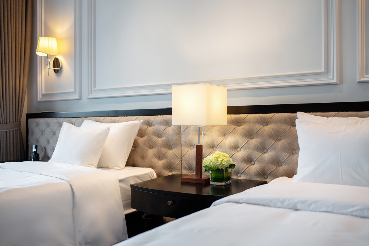 Luxury hotel bedroom with twin beds, elegant decor, and cozy lighting for a relaxing stay.