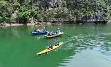 Kayaking in Lan Ha Bay with lush green cliffs and calm waters, perfect for adventure and relaxation.