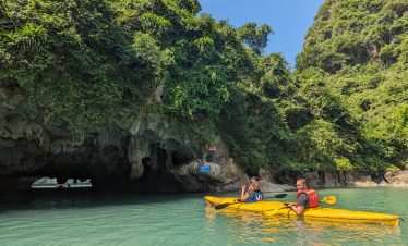 Kayaking adventure in Lan Ha Bay with lush green cliffs and clear turquoise waters.