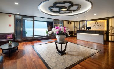 Elegant cruise lounge with panoramic view of Halong Bay, modern decor, and relaxing ambiance.