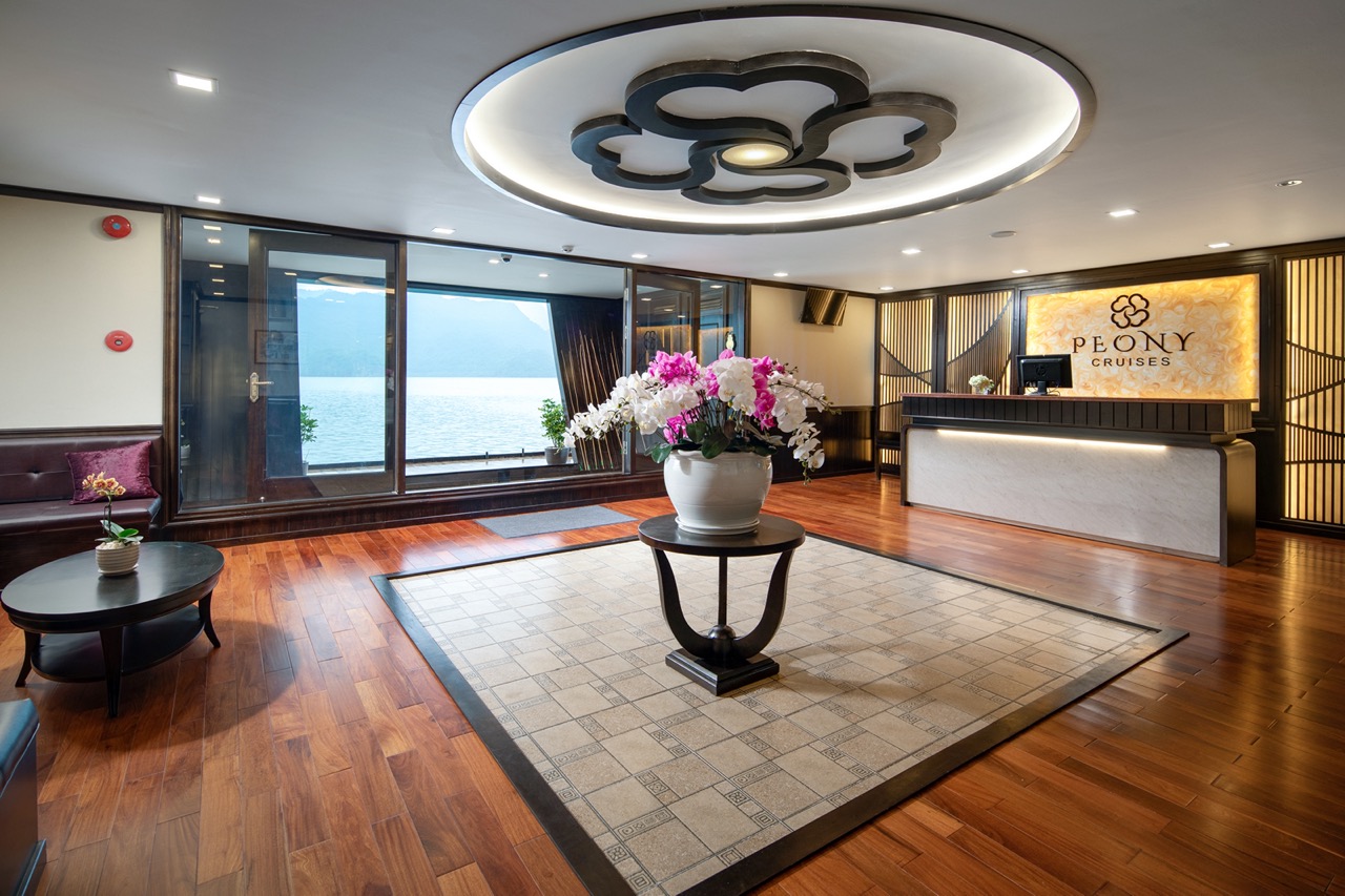 Elegant cruise lounge with panoramic view of Halong Bay, modern decor, and relaxing ambiance.
