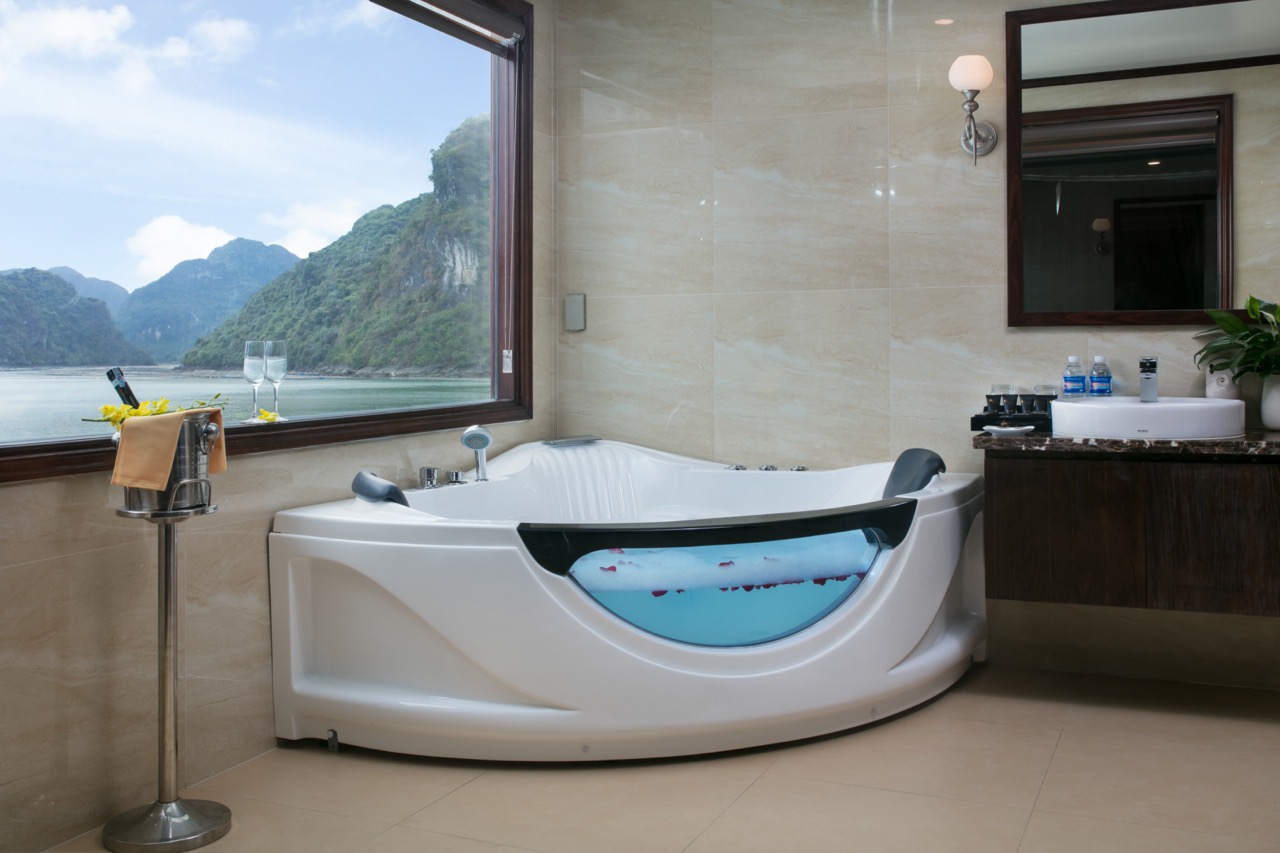 Relaxing bath with stunning Halong Bay views from cruise balcony.