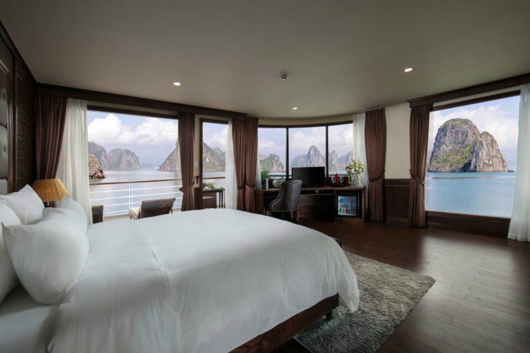 Stunning view from a luxury cruise balcony in Halong Bay, showcasing serene waters and towering lime.