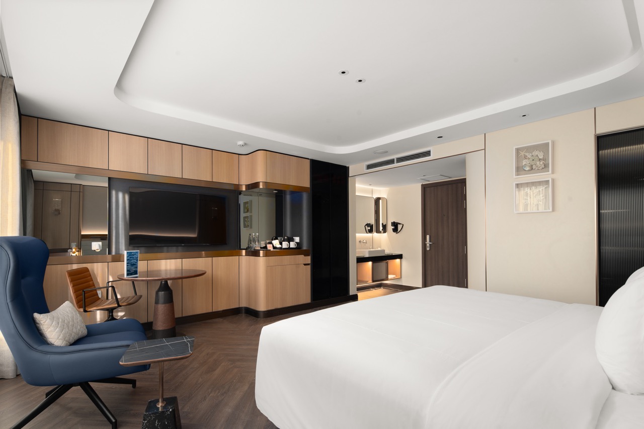 Luxury hotel room with modern decor, flat-screen TV, and cozy seating area for a premium Vietnam travel experience.