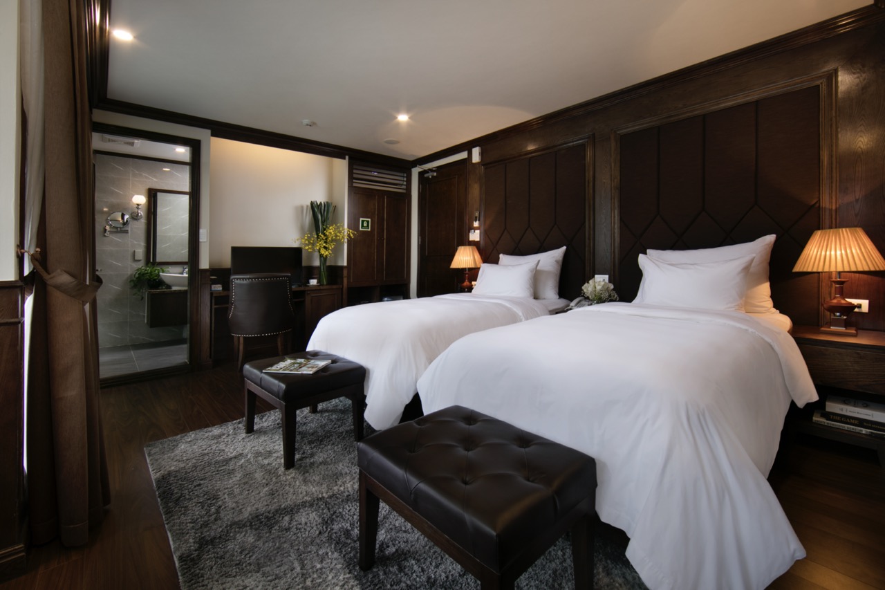 Elegant cruise balcony with comfortable beds and modern decor in Halong Bay.