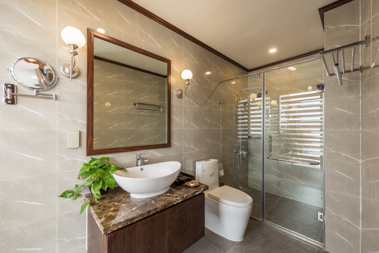 Luxurious bathroom with modern fixtures on Halong Bay cruise, showcasing comfort and style.