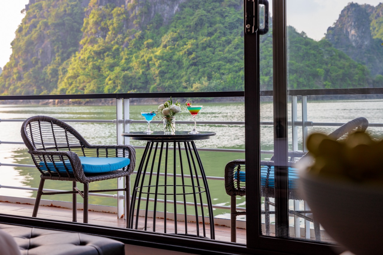 Beautiful view of Halong Bay from a cruise balcony with seating and scenic limestone karsts in the b.