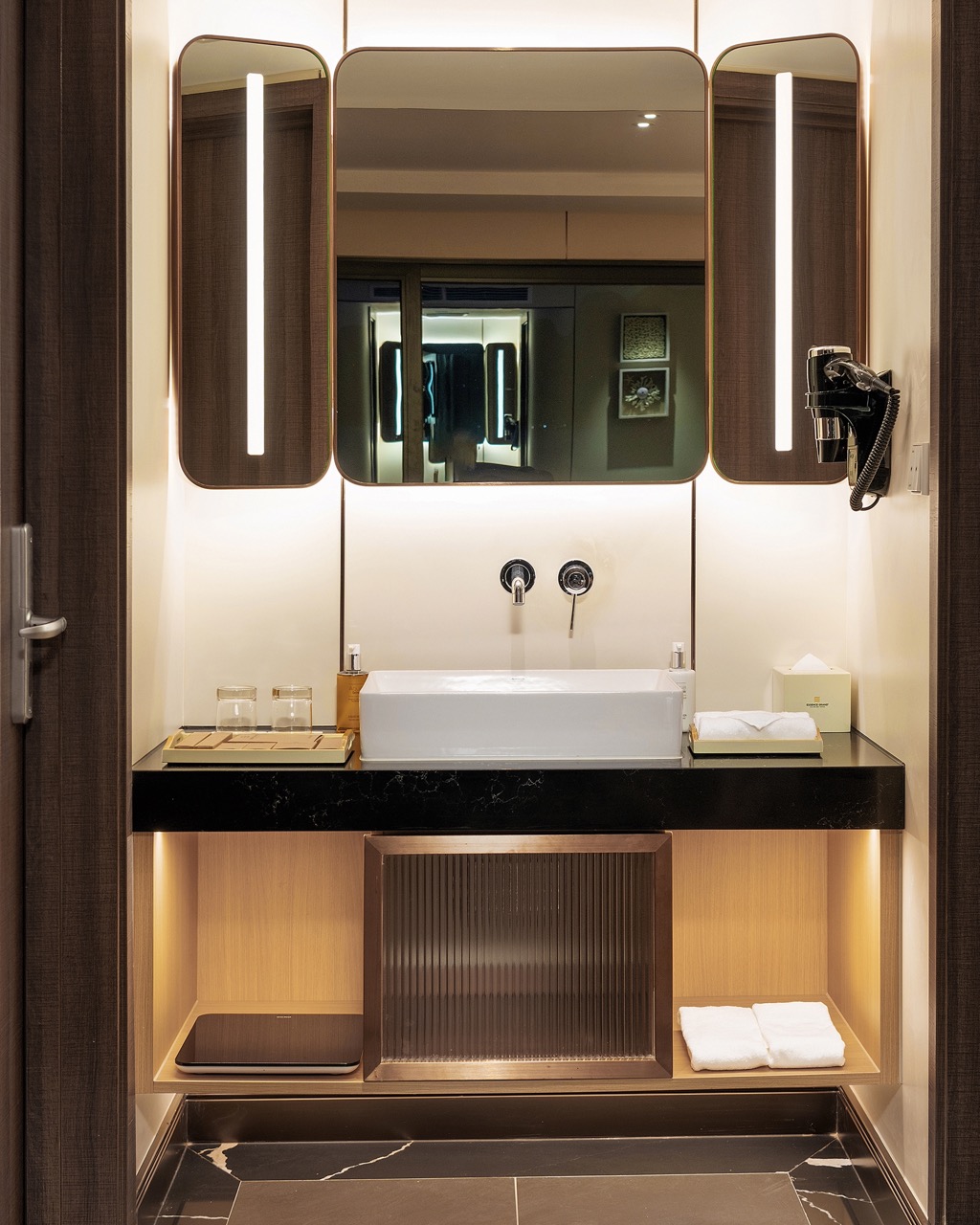 Bright modern hotel bathroom with stylish mirrors and premium amenities.