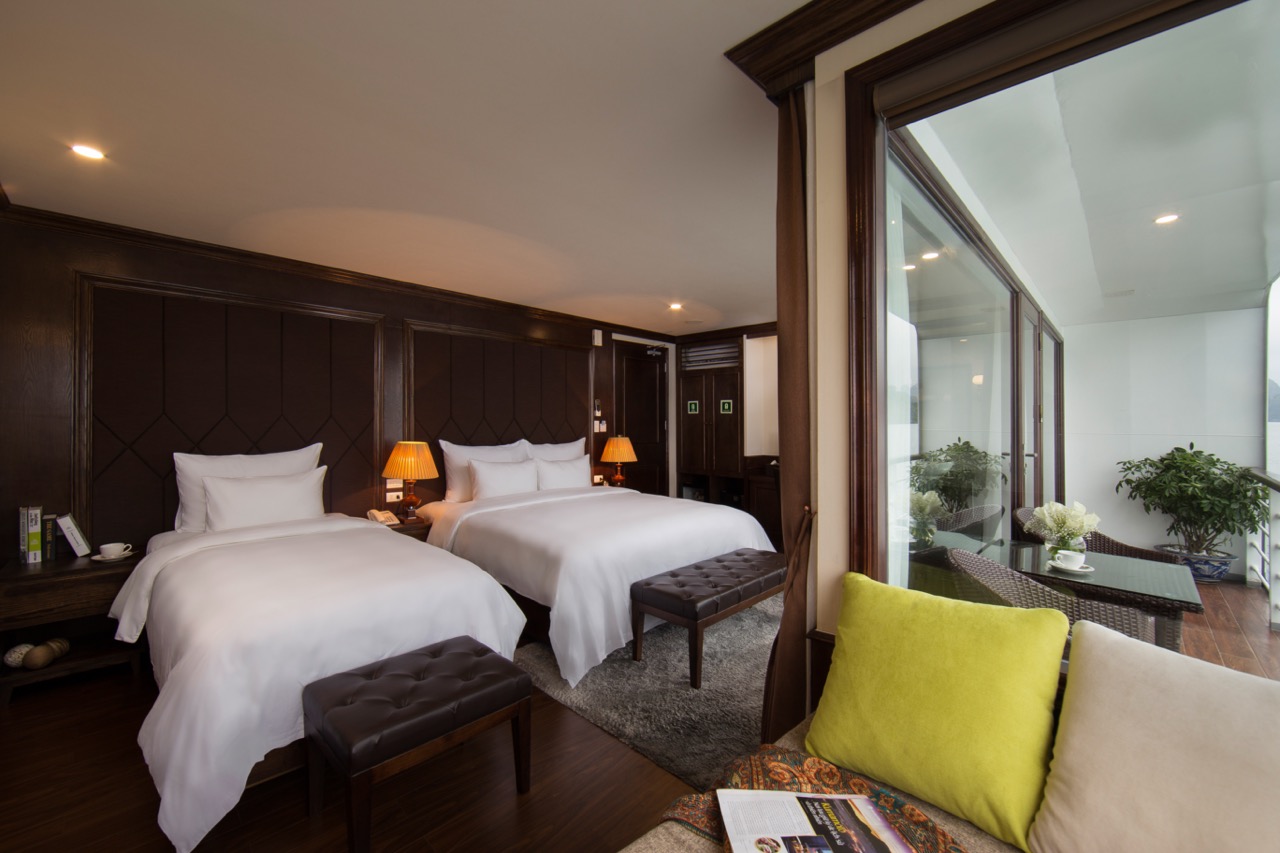 Comfortable cruise balcony view of Halong Bay with serene waters and lush islands.