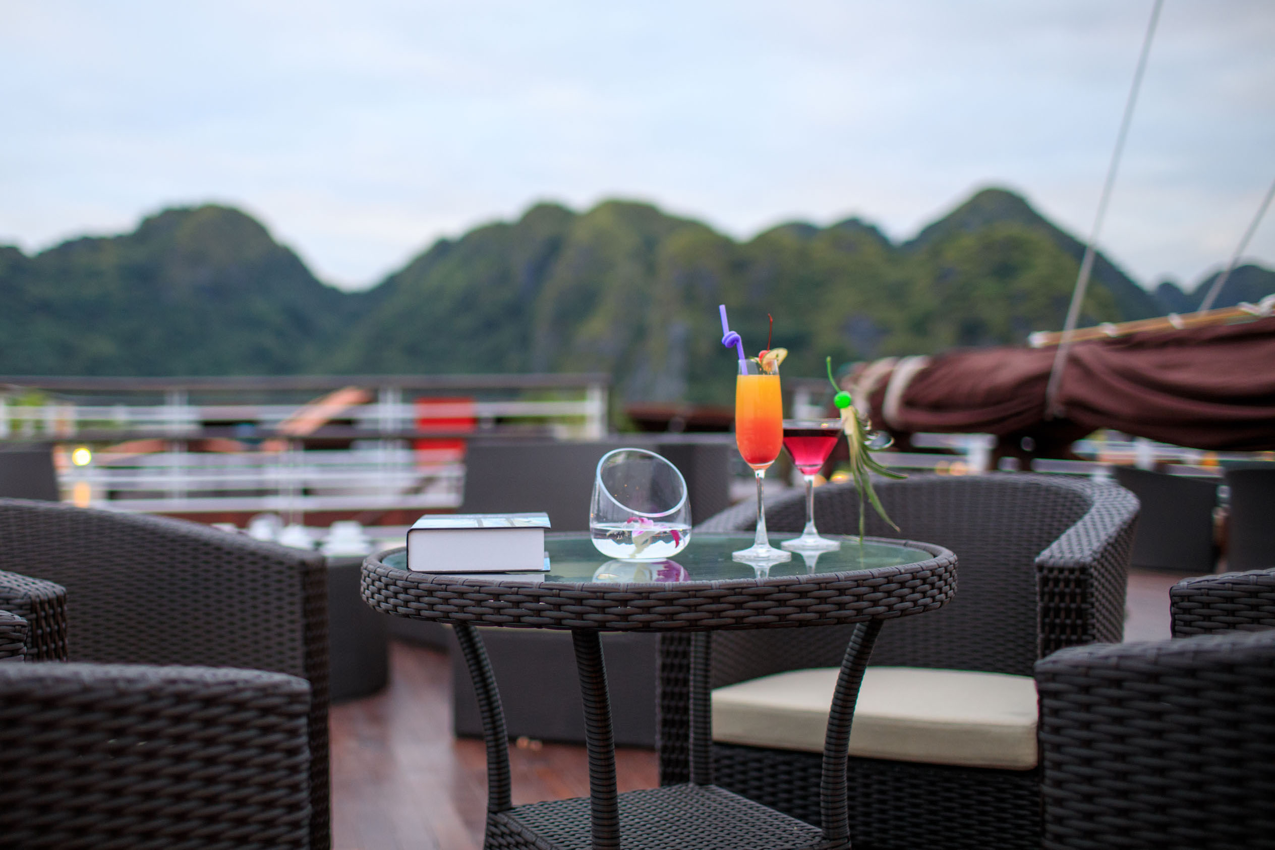 Bright cocktails on a terrace overlooking lush green mountains, perfect for Vietnam travel experiences.