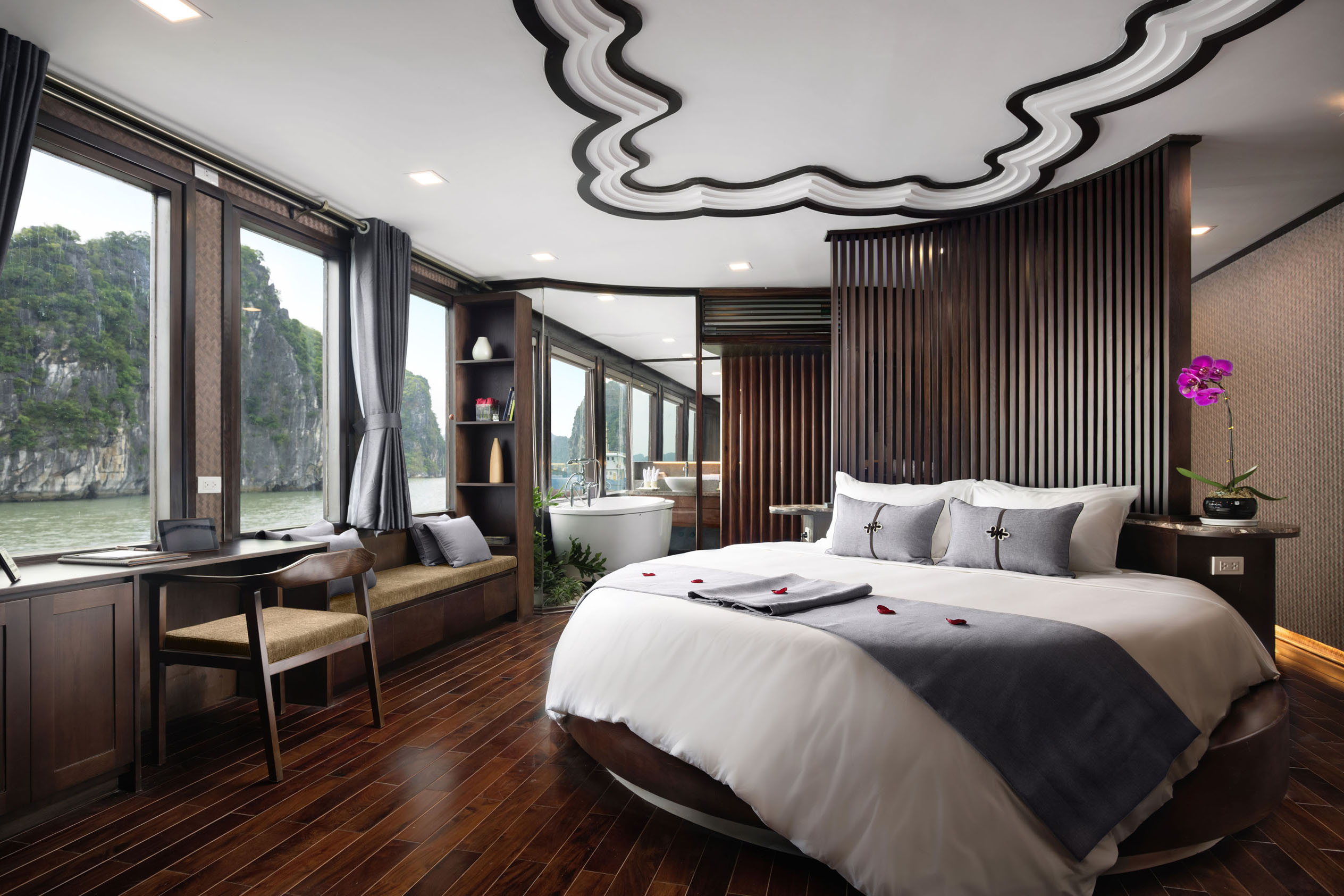 Luxurious river-view hotel bedroom with modern decor and bathtub at ViettrendTour.