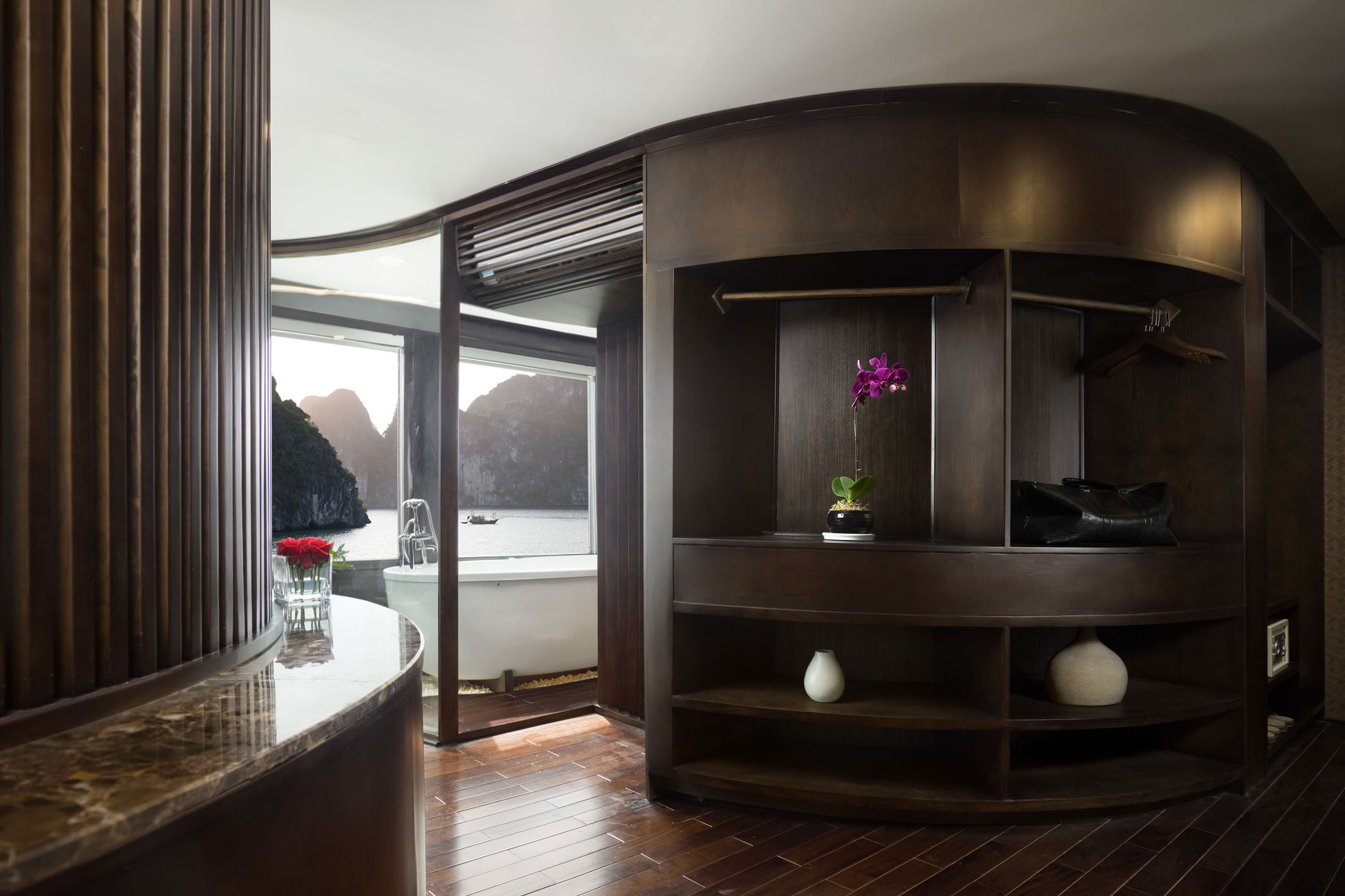 Elegant wooden hotel room with ocean view and bathtub, showcasing luxurious hospitality in Vietnam.