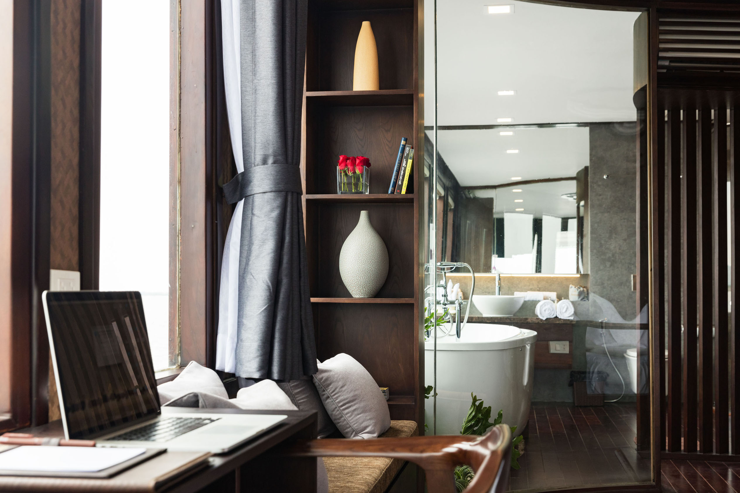 Luxurious hotel bathroom with bathtub, window seat, and modern design.
