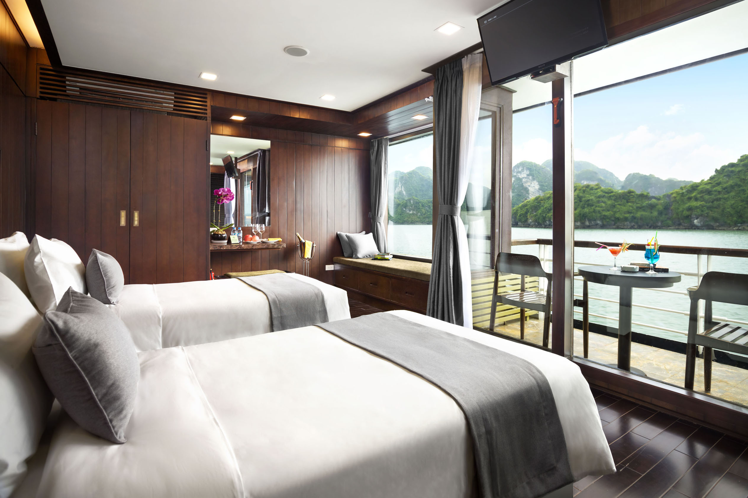Luxurious lake view hotel room with balcony, modern decor, and scenic mountain surroundings.