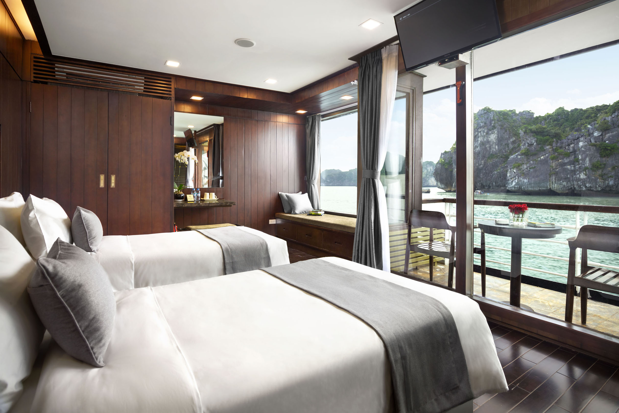 Elegant water-view hotel room with twin beds, balcony, and modern amenities in Vietnam.