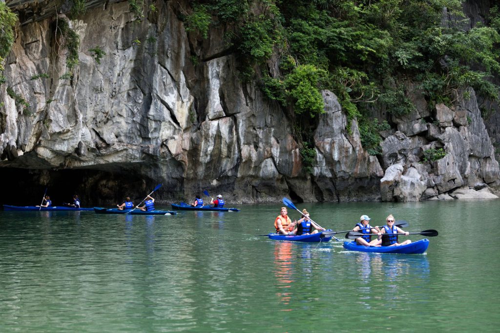 Kayaking adventure in stunning limestone caves and lush greenery in Vietnam.