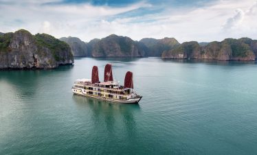 Orchid classic cruise halong bay - a luxurious cruise boat sailing through stunning Halong Bay with towering limestone islands.