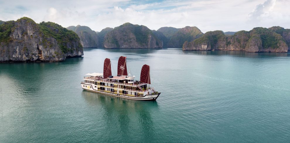 Orchid classic cruise halong bay - a luxurious cruise boat sailing through stunning Halong Bay with towering limestone islands.