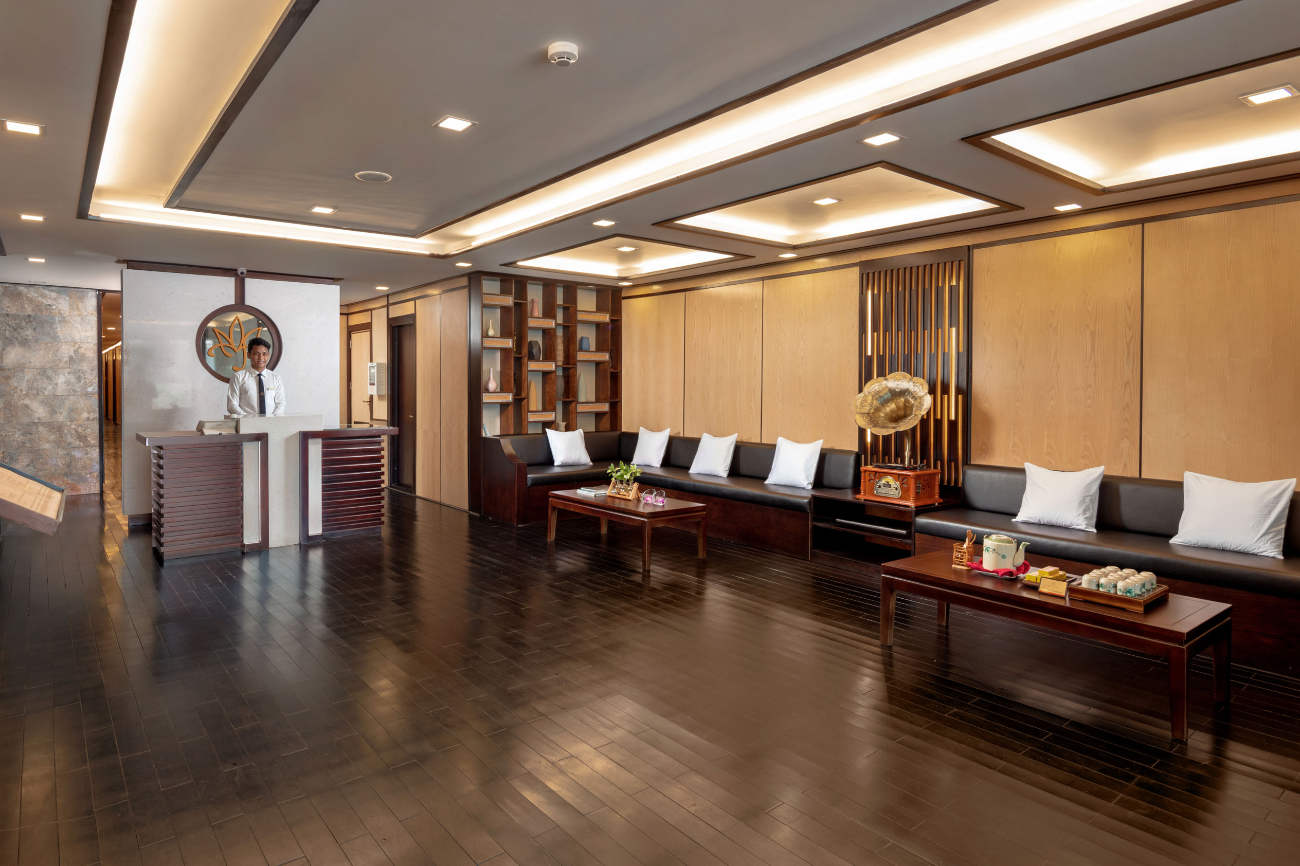 Elegant hotel lobby with modern decor, wooden accents, and comfortable seating area for guests.